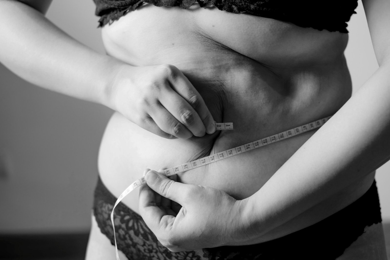 Mulher medindo a circunferência da cintura com fita métrica