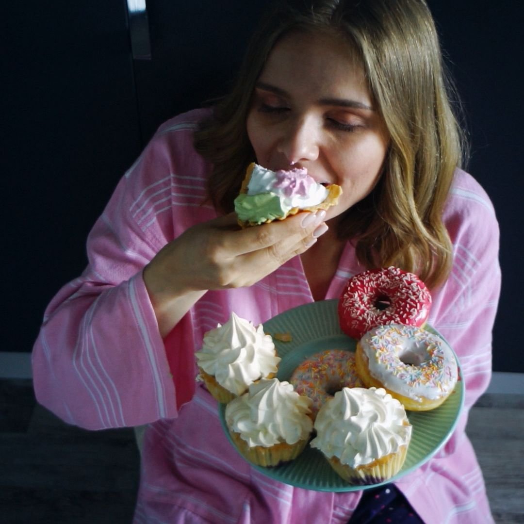 Mulher consumindo doces de forma impulsiva em momento de ansiedade alimentar