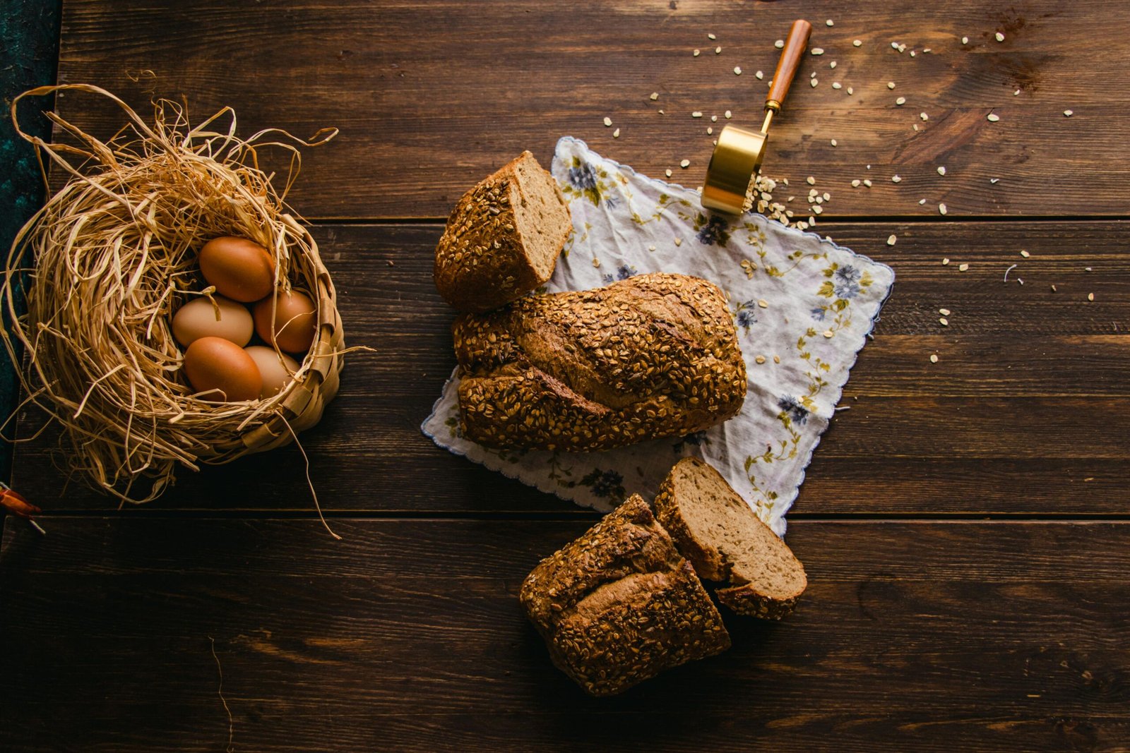 Pão de aveia e banana sem glúten servido em mesa de madeira com ovos e flores”