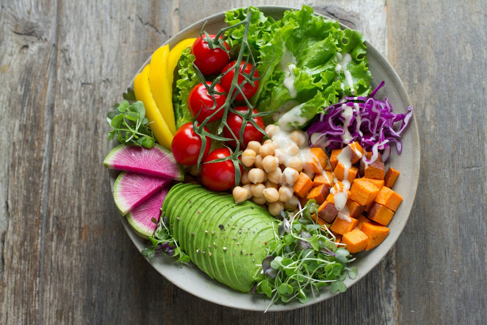 Salada colorida com molho de iogurte em prato redondo